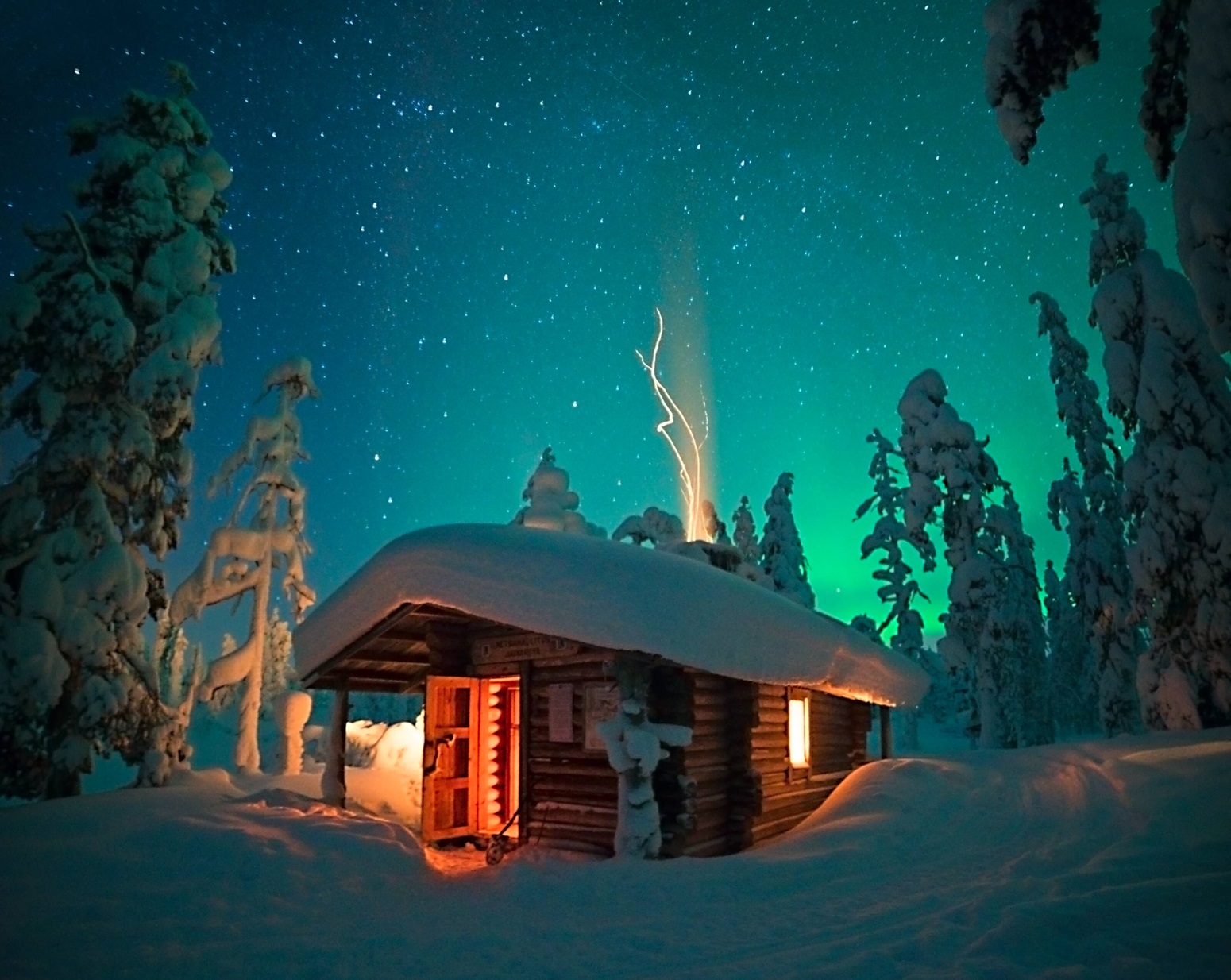 Cabaña bajo la aurora boreal